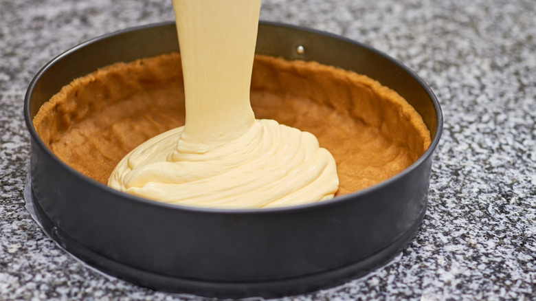 Η πλήρωση cheesecake χύνεται σε κρούστα