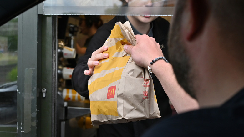 Ο πελάτης παραλαμβάνει την τσάντα McDonald's Drive-thru